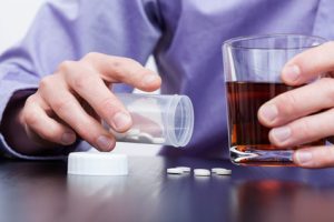 Man is drinking alcohol and taking pills Dangers of mixing drugs